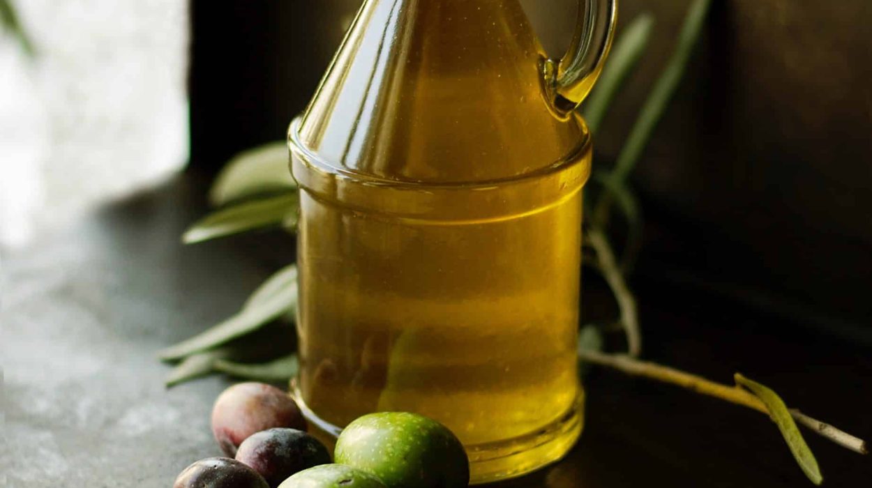 Flacon d'huile posé sur une table, olives, branche d'olivier