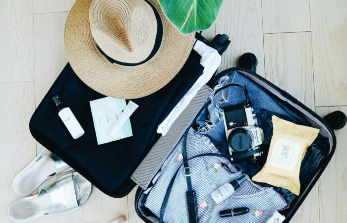 valise ouverte, chapeau, appareil photo