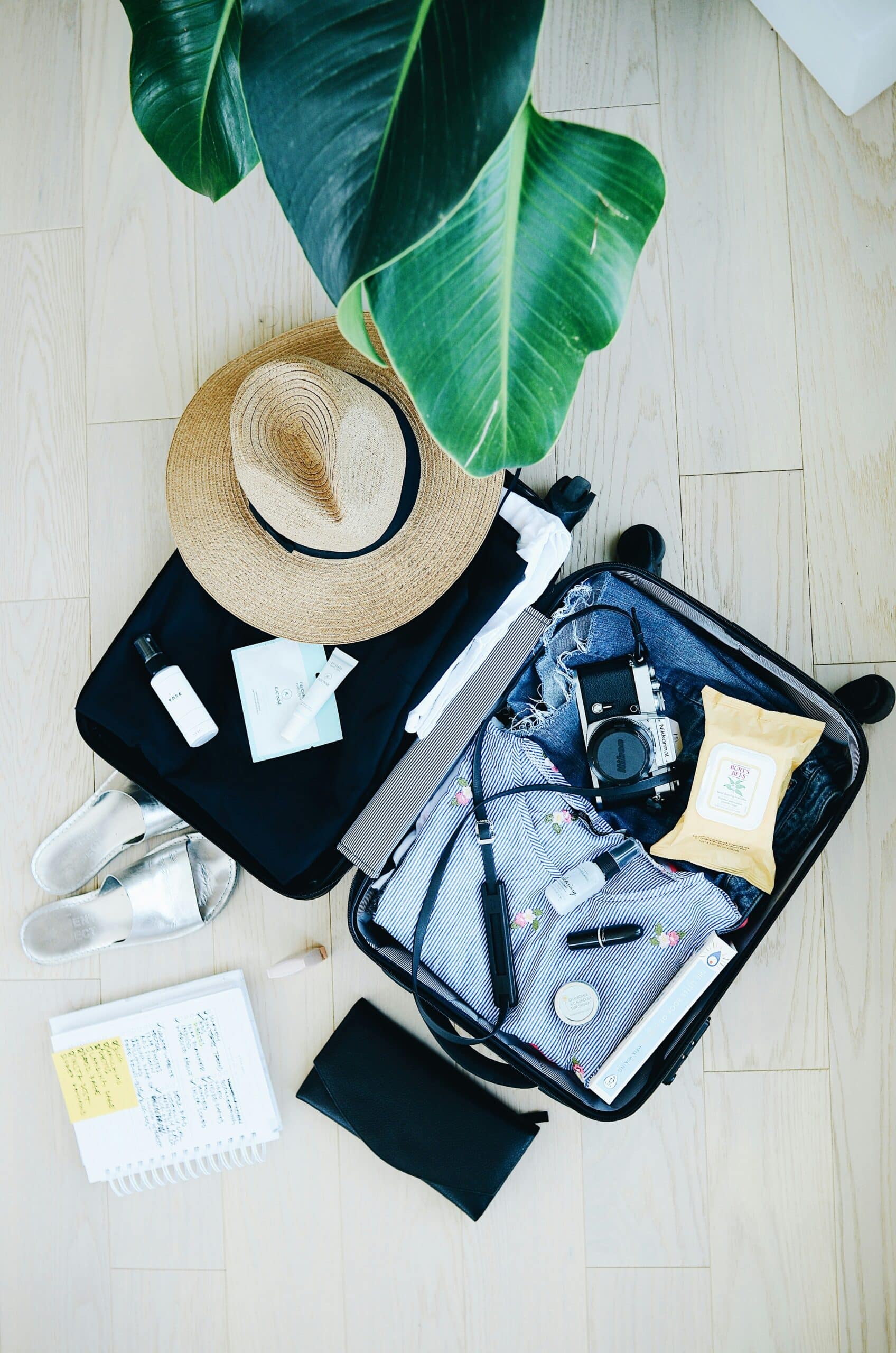 valise ouverte, chapeau, appareil photo